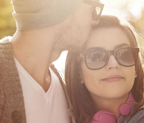 Hombre besando a una mujer en un parque