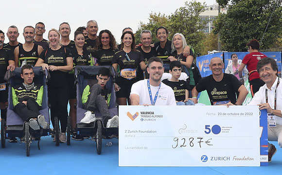 participantes de una carrera con discapacidades diversar frente a un cheque de 9.287 euros