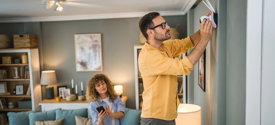 Persona colocando una cámara de vigilancia dentro de su casa